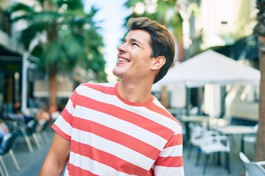 Genç beyaz adam gülümsüyor.