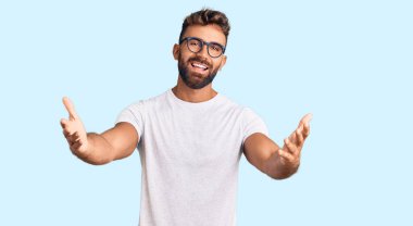 Gündelik kıyafetler ve gözlük takan genç İspanyol adam gülümseyerek yardım eli uzatıyor ve kabul ediyor.. 