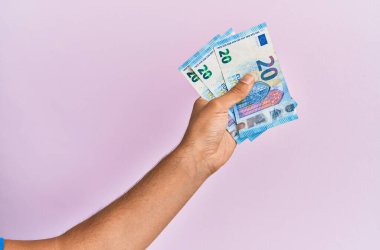 Hispanik el, izole edilmiş pembe arka planda 50 avroluk banknot tutuyor..