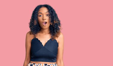 Genç Afro-Amerikalı kadın günlük kıyafetler giyiyor. Şaşırtıcı bir ifade, korku ve heyecan dolu bir yüz ifadesi var.. 