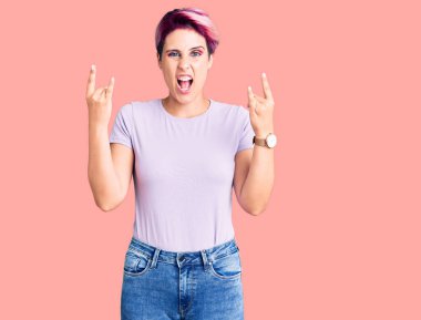 Pembe saçlı, sıradan kıyafetler giyen, çılgın bir ifadeyle bağıran, elleri havada rock sembolü yapan genç ve güzel bir kadın. Müzik yıldızı. ağır kavram. 