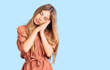 Sarışın, güzel, beyaz bir kadın. Yazlık tulum giyiyor. Yorgun uyuyor.. 