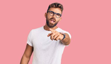 Gündelik kıyafetler giyen ve gözlük takan genç İspanyol adam kameraya kızgın ve sinirli olduğunu gösteriyor. 