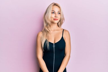 Güzel, beyaz, sarışın, seksi parti elbisesi giyen, gülümseyen, yan bakan ve düşünen bir kız.. 