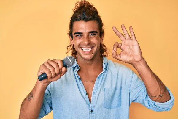 Молодий Іспаномовний Чоловік Співає Пісню Використовуючи Мікрофон Роблячи Знак Пальцями — стокове фото