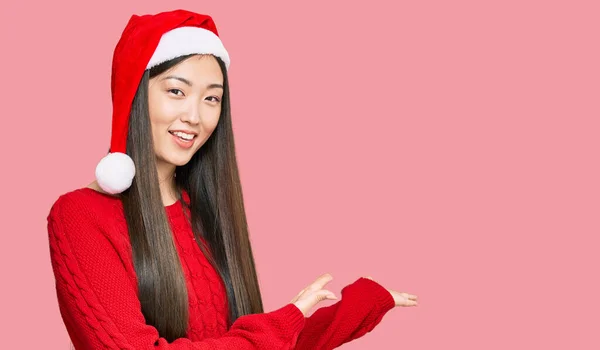 若いです中国の女性身に着けているクリスマスの帽子招待状に笑顔自然とともにオープン手 — ストック写真