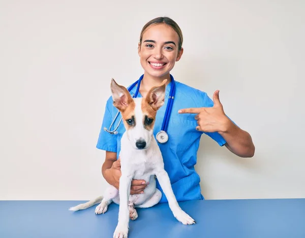 Young Beautiful Blonde Veterinarian Woman Checking Dog Health Pointing Finger — Stock Photo, Image