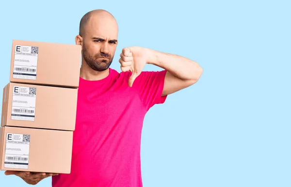 Joven Hombre Guapo Sosteniendo Paquete Entrega Con Cara Enojada Signo — Foto de Stock