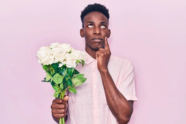 Jeune Homme Afro Américain Tenant Des Fleurs Visage Sérieux Pensant — Photo