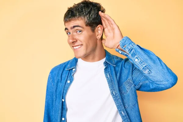 Mladý Pohledný Muž Neformálních Šatech Usmívající Rukou Uchem Naslouchající Drbům — Stock fotografie