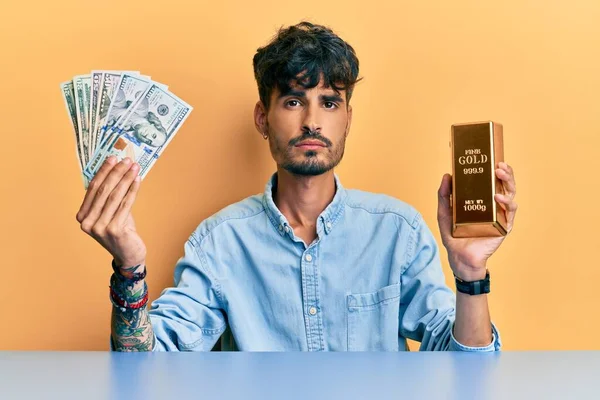 Joven Hombre Hispano Sosteniendo Dólares Lingote Oro Relajado Con Expresión — Foto de Stock