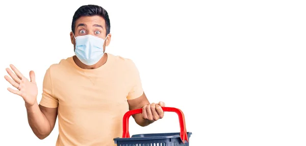 Young Hispanic Man Wearing Shopping Basket Medical Mask Celebrating Victory — Stock Photo, Image