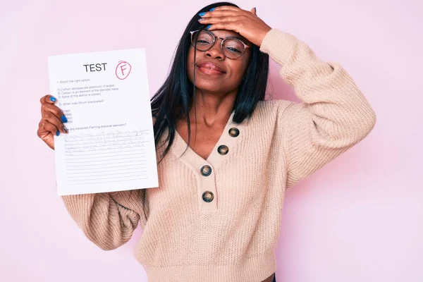 Young african american woman showing a failed exam stressed and frustrated with hand on head, surprised and angry face