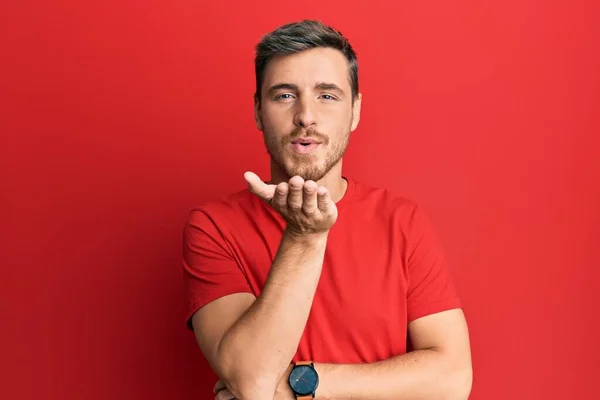 Hombre Caucásico Guapo Vistiendo Camiseta Roja Casual Mirando Cámara Soplando — Foto de Stock