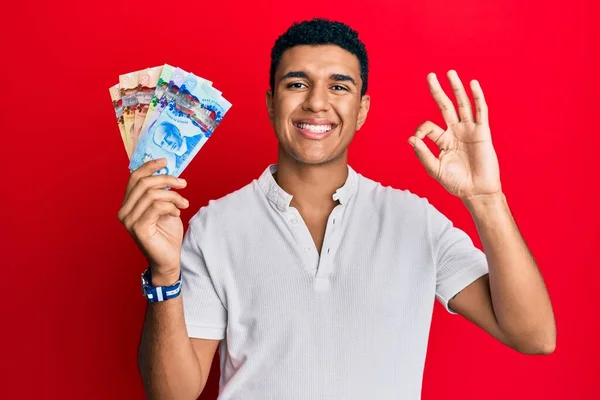 Hombre Árabe Joven Sosteniendo Dólares Canadienses Haciendo Signo Con Los —  Fotos de Stock