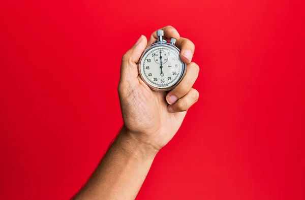 Main Jeune Homme Hispanique Utilisant Chronomètre Sur Fond Rouge Isolé — Photo