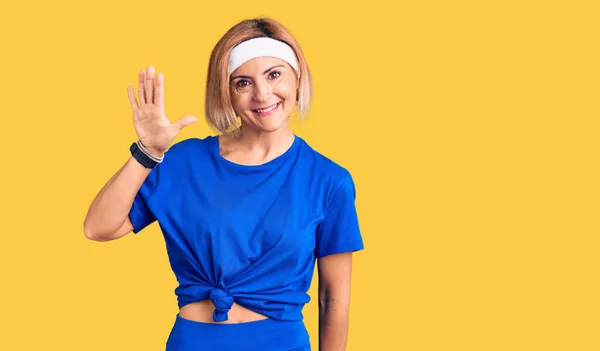 Spor Kıyafetleri Giyen Genç Sarışın Kadın Beş Numarayı Gösterip Işaret — Stok fotoğraf