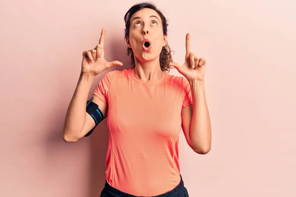 Young Beautiful Hispanic Woman Wearing Sportswear Using Smartphone Amazed Surprised — Stock Photo, Image