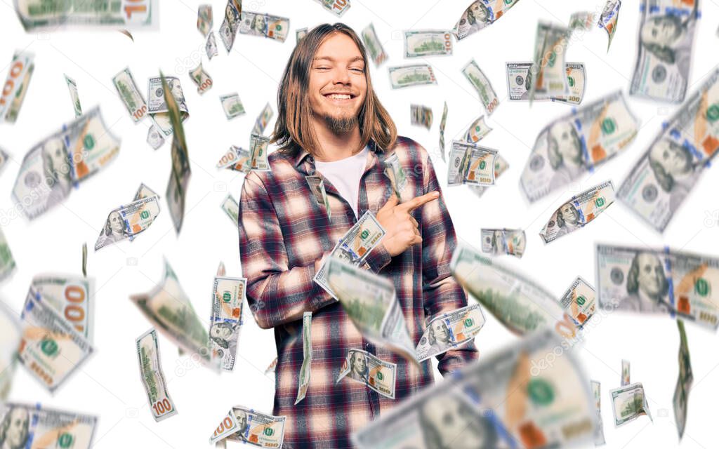Handsome caucasian man with long hair wearing hipster shirt cheerful with a smile of face pointing with hand and finger up to the side with happy and natural expression on face