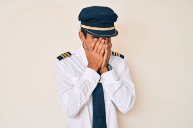 Genç İspanyol pilot üniforması giyiyor. Ağlarken yüzünü ellerle kapatıyor. depresyon kavramı. 