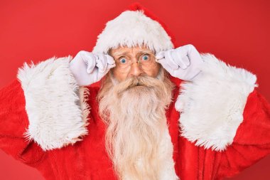 Gri saçlı, uzun sakallı, Noel Baba kostümü giyen, şok olmuş gözlüklü, şüpheci ve alaycı bakışlı, ağzı açık bir şekilde şaşırmış yaşlı bir adam. 