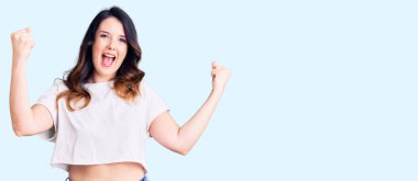 Güzel, genç, esmer bir kadın gündelik giysiler içinde gururla bağırıyor, zaferi kutluyor ve kollarını kaldırarak çok heyecanlanıyor. 