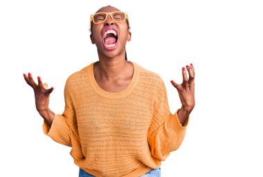 Genç Afro-Amerikalı kadın, günlük kıyafetler ve gözlük takıyor. Deli gibi bağırıyor, bağırıyor, agresif bir ifade ve kollarla bağırıyor. hüsran kavramı. 