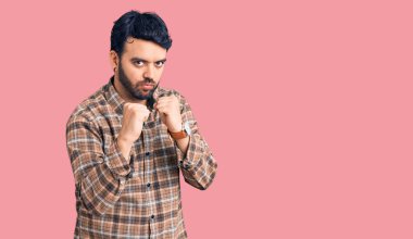 Latin asıllı genç adam gündelik giysiler giyiyor. Yumruk savunma hareketiyle dövüşmeye hazır. Kızgın ve üzgün yüz, sorundan korkuyor. 