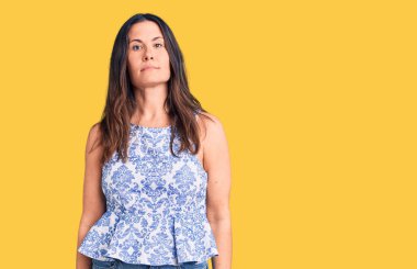 Genç, güzel, esmer bir kadın. Günlük tişört giyiyor. Yüzünde ciddi bir ifade var. Basit ve doğal bir şekilde kameraya bakıyorsun.. 