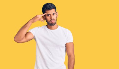 Gündelik giysiler giyen genç Latin bir adam. Alnındaki sorun yüzünden endişeli ve stresli. Kriz için endişeli. 