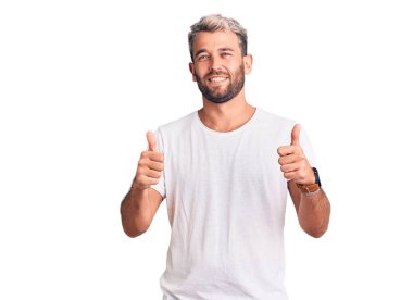 Genç, sarışın, sıradan tişörtler giyen çılgın ve deli gibi bağıran saldırgan bir ifade ve kollarla bağıran genç bir adam. hüsran kavramı. 