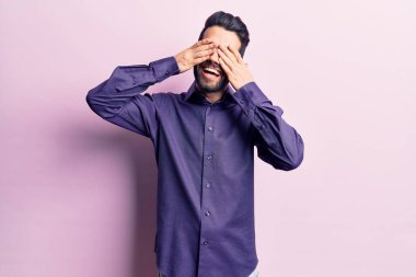 Sakallı, sıradan gömlekli, elleri gülücüklü ve neşeli gözleri olan genç yakışıklı bir adam. kör kavram. 