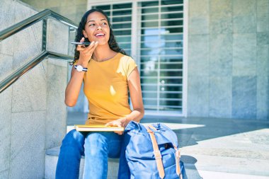 Genç Afrikalı Amerikalı öğrenci üniversitedeki akıllı telefonu kullanarak sesli mesaj gönderiyor..