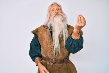 Gri saçlı, uzun sakallı, Viking kostümü giyen yaşlı bir adam İtalyan jesti yapıyor. 