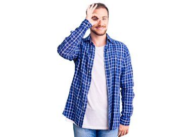 Genç, beyaz, sıradan kıyafetler giyen, el hareketleriyle gülümseyen, mutlu yüzüyle parmaklarının arasından bakan yakışıklı bir adam.. 