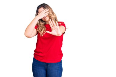 Kafkasyalı genç bir kadın, günlük kıyafetler giyip, elleriyle gözlerini kapatıyor ve üzgün ve korku ifadeleriyle jestleri durduruyor. utangaç ve olumsuz kavram. 