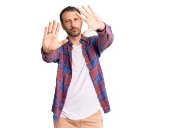 Gündelik kıyafetler giyen, el ve parmaklarını kullanarak çerçeve yapan genç yakışıklı bir adam. Kamera bakış açısı. 