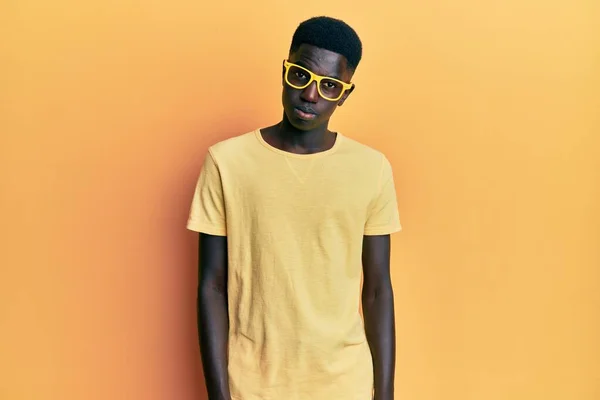 若いアフリカ系アメリカ人の男性は カジュアルな服と眼鏡を懐疑的かつ神経を着て 問題のために動揺を眉をひそめています 否定的な人 — ストック写真