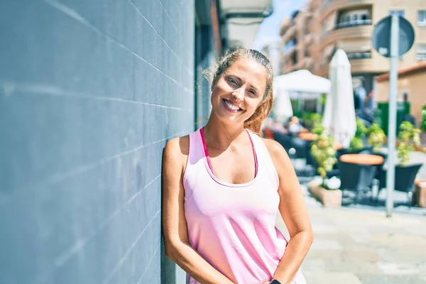 Middelbare Leeftijd Sportvrouw Glimlachen Gelukkig Leunend Muur Stad — Stockfoto