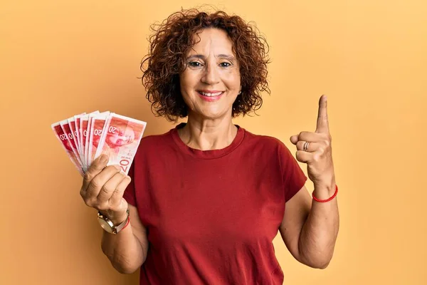 Красива Зріла Жінка Середнього Віку Тримає Банкноти Шекелів Ізраїлю Посміхаючись — стокове фото