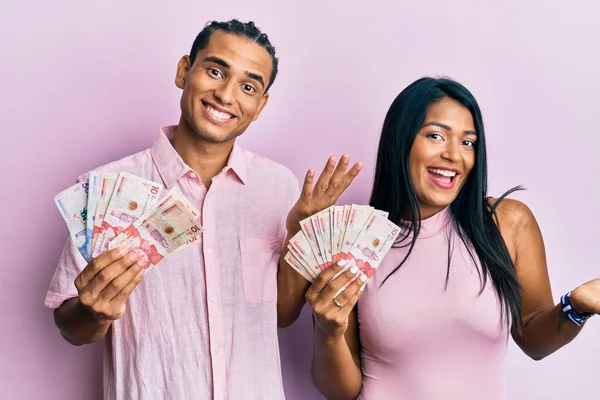 Jovem Casal Latino Segurando Pesos Colombianos Comemorando Realização Com Sorriso — Fotografia de Stock