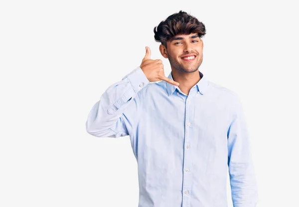 Joven Hombre Hispano Con Camisa Casual Sonriendo Haciendo Gesto Telefónico —  Fotos de Stock