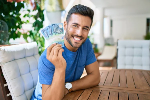 Junger Hispanischer Mann Lächelt Glücklich Und Hält Australische Dollarnoten Auf — Stockfoto