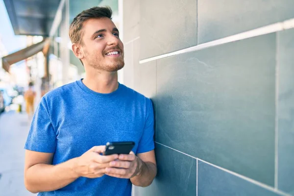 Joven Hombre Caucásico Sonriendo Feliz Usando Teléfono Inteligente Ciudad —  Fotos de Stock