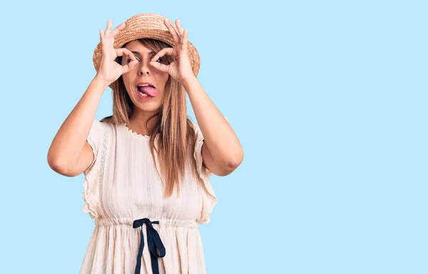 Young Beautiful Woman Wearing Summer Hat Shirt Doing Gesture Binoculars — Stock Photo, Image