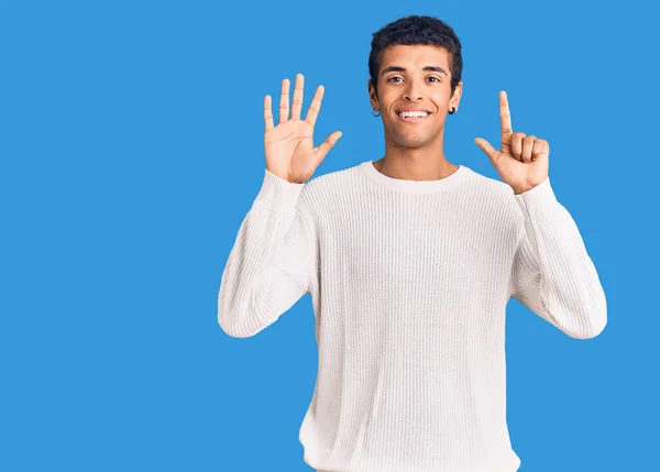 自信を持って幸せな笑みを浮かべている間 若いアフリカ系アメリカ人の男性は カジュアルな服を着て指の数7を示すと指摘 — ストック写真
