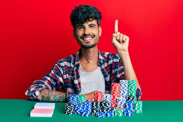 Jovem Hispânico Sentado Mesa Com Fichas Poker Cartas Sorrindo Com — Fotografia de Stock