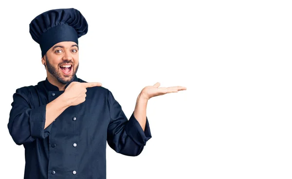 요리용 유니폼을 스페인 손가락으로 가리키는 카메라 앞에서 놀라며 미소짓고 있었다 — 스톡 사진