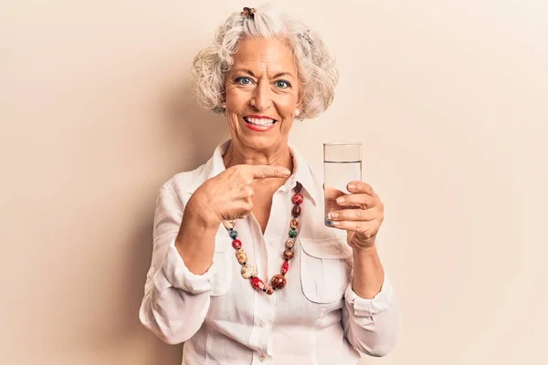 Senior Mulher Cabelos Grisalhos Beber Copo Água Sorrindo Feliz Apontando — Fotografia de Stock