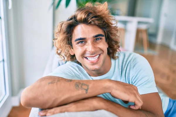 Joven Hombre Hispano Sonriendo Feliz Sentado Sofá Casa —  Fotos de Stock